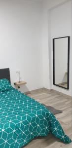 a bedroom with a blue comforter and a mirror at Alexa suite in Las Palmas de Gran Canaria