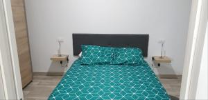a bedroom with a bed with a blue comforter at Alexa suite in Las Palmas de Gran Canaria