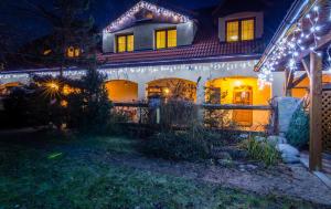 a house with christmas lights on it at night at Apartmany Centrum in Pavčina Lehota