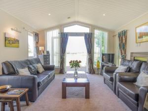 ein Wohnzimmer mit 2 Sofas und einem Tisch in der Unterkunft The Lodge At Newmeads Farm in West Pennard