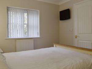 a bedroom with a white bed and a window at Hollies Cottage 5 - Ukc4521 in Martock