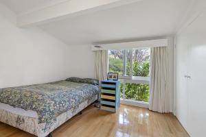 a bedroom with a bed and a window at Beach Side in Aireys Inlet