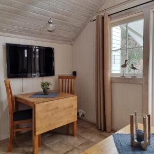 jadalnia z drewnianym stołem i oknem w obiekcie Bergland apartment 24 w mieście Kragerø