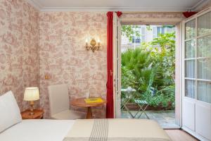 een slaapkamer met een bed en een raam bij Hotel des Grandes Ecoles in Parijs