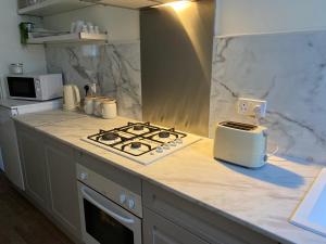 a kitchen counter with a stove and a toaster on it at Fernlea spacious apartment in Arbroath