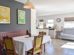 a kitchen and dining room with a table and chairs at Hafan Fach Cottage in Pembroke