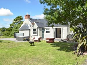 a white house with a lawn in front of it at Hafan Fach Cottage in Pembroke