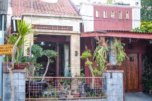 a house with potted plants in front of it at Unique Homestay 443 in Yogyakarta