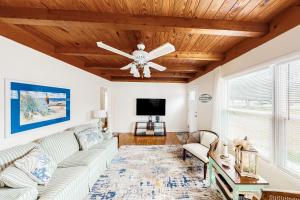 a living room with a couch and a ceiling fan at Ginny's Coastal Cottage in Oak Island