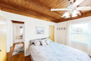 a bedroom with a bed and a ceiling fan at Ginny's Coastal Cottage in Oak Island