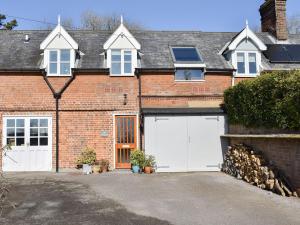 a brick house with two white garage doors at The Stables in Bealings