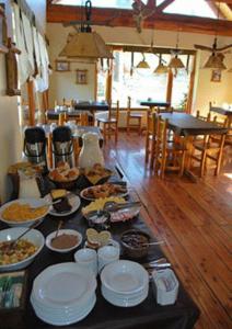 una mesa con muchos platos de comida. en Hostería Traunco en Villa La Angostura