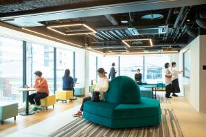 a group of people in an office with a green couch at Prince Smart Inn Hakata in Fukuoka