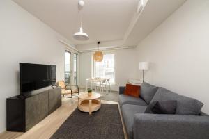 un soggiorno con divano e TV di ULEABO Neat 48 m2 two-room flat with sauna a Oulu