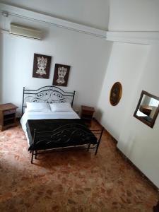 a bedroom with a black bed in a white room at Arco del vescovo 2 in Acireale