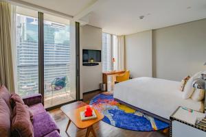 - une chambre avec un lit et une grande fenêtre dans l'établissement Hotel Indigo Bangkok Wireless Road, an IHG Hotel, à Bangkok
