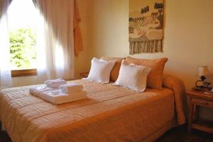 1 cama con 2 toallas y ventana en Hostería Traunco en Villa La Angostura