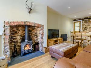 a living room with a brick fireplace and a couch at Hidden Winds Cottage in Guisborough