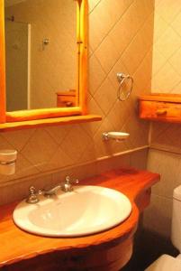 y baño con lavabo y espejo. en Hostería Traunco en Villa La Angostura