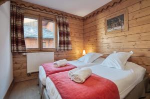 2 Betten in einem Zimmer mit Holzwänden in der Unterkunft Appartement Ecrin 214 in Tignes