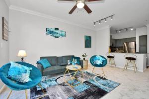a living room with a couch and two blue chairs at The Turquoise Suite in Houston
