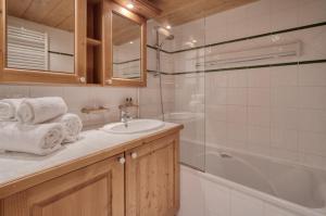 a bathroom with a sink and a shower and a tub at Appartement Ecrin 426 in Tignes