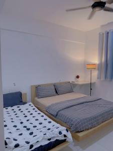 um quarto com 2 camas e um candeeiro em Home Feel-Hibiscus Suites em Kampar