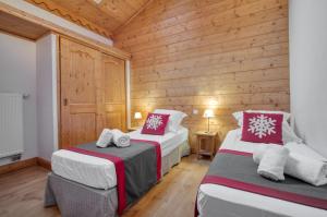 a bedroom with two beds in a wooden cabin at Appartement Ecrin 426 in Tignes