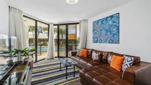 a living room with a couch and a glass table at 108 The Boathouse in Tea Gardens