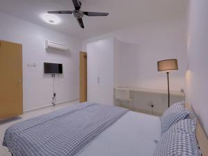 - une chambre blanche avec un lit et un ventilateur de plafond dans l'établissement Home Feel-Hibiscus Suites, à Kampar