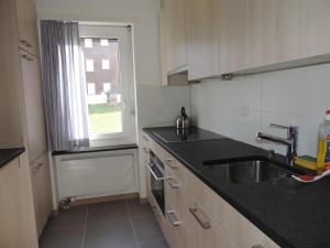 una pequeña cocina con fregadero y ventana en Palousa (352 Br), en Valbella