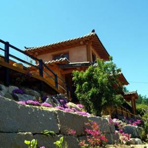 a house with a bunch of flowers in front of it at Saranbang Pension in Gapyeong