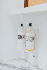 two bottles of soap sitting on a shelf at Senhora do Cabo Meco Homy Holidays in Sesimbra