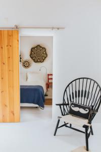 a bedroom with a black chair and a bed at Senhora do Cabo Meco Homy Holidays in Sesimbra