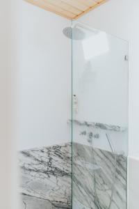 a shower in a white bathroom with a glass wall at Senhora do Cabo Meco Homy Holidays in Sesimbra