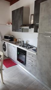 a kitchen with a stove top oven and a microwave at Helianthus in Assemini