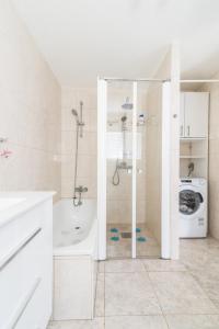 ein Badezimmer mit einer Dusche, einer Badewanne und einer Waschmaschine in der Unterkunft Home2Book Stunning Apartment Rocas Rojas in San Bartolomé de Tirajana