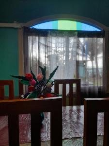 a vase of flowers on a table with a window at Toni Arts Villa in Nabas