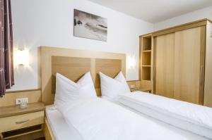 1 dormitorio con 2 camas y almohadas blancas en Apart Maurice, en Galtür