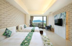 Habitación de hotel con 2 camas y TV de pantalla plana. en Hu Yue Lakeview Hotel en Yuchi