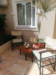 a patio with chairs and a table and a window at Toxo Hotel in Platanias