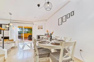 a dining room and living room with a table and chairs at Maison Arlette in Mijas Costa