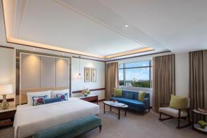 Habitación de hotel con cama grande y sofá en Tajview Agra-IHCL SeleQtions, en Agra