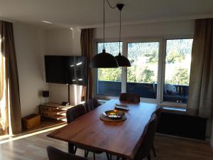 a dining room table with chairs and a large window at Ferienwohnungen Kienesberger in Tiefgraben