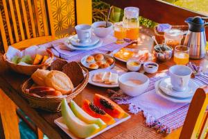 una mesa cubierta con platos de comida y fruta en Pousada do Sonho, en Visconde De Maua