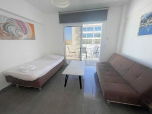 Un dormitorio con una cama, un sofá y una mesa. en Christina Apartment, en Protaras