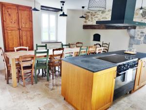 cocina y comedor con mesa y sillas en Le Val Éveillé 4 étoiles - maison de maître de 1773, en Arudy