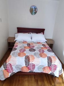 a bedroom with a bed with a colorful bedspread at Dulce Hogar 02 in Loja