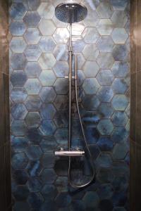 y baño con ducha y azulejos azules y blancos. en KeizersgrachtSuite471, en Ámsterdam