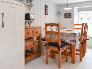 a kitchen with a table and chairs and a dining room at Zion Cottage in Gorran Haven